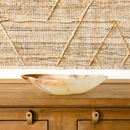Handcrafted onyx stone bowl in neutral home decor setting with woven wall art