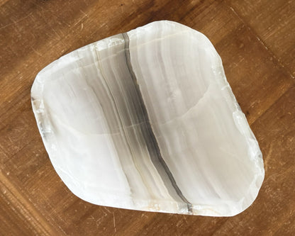 Artisan-carved grey onyx bowl with layered grey and white mineral patterns