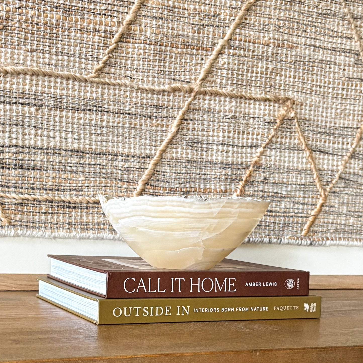 Small hand-carved grey onyx bowl with natural stone banding styled on decorative books for modern shelf decor