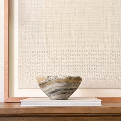 Sculptural grey onyx bowl showcasing unique veining and hand-carved craftsmanship.