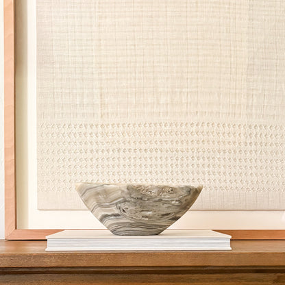 Hand-carved grey onyx bowl styled on a console table in a modern organic living room.