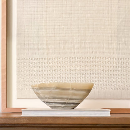Natural grey onyx decorative bowl displayed on a console table with curated home décor.