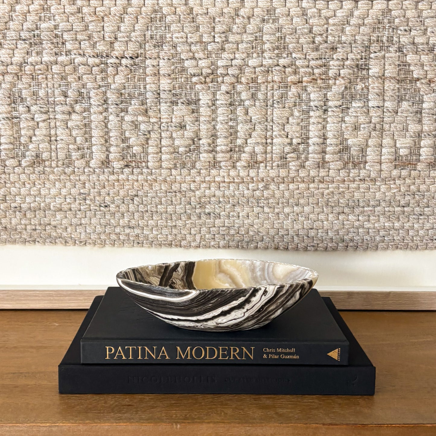 Small zebra onyx decorative bowl with natural striped stone pattern on wooden console