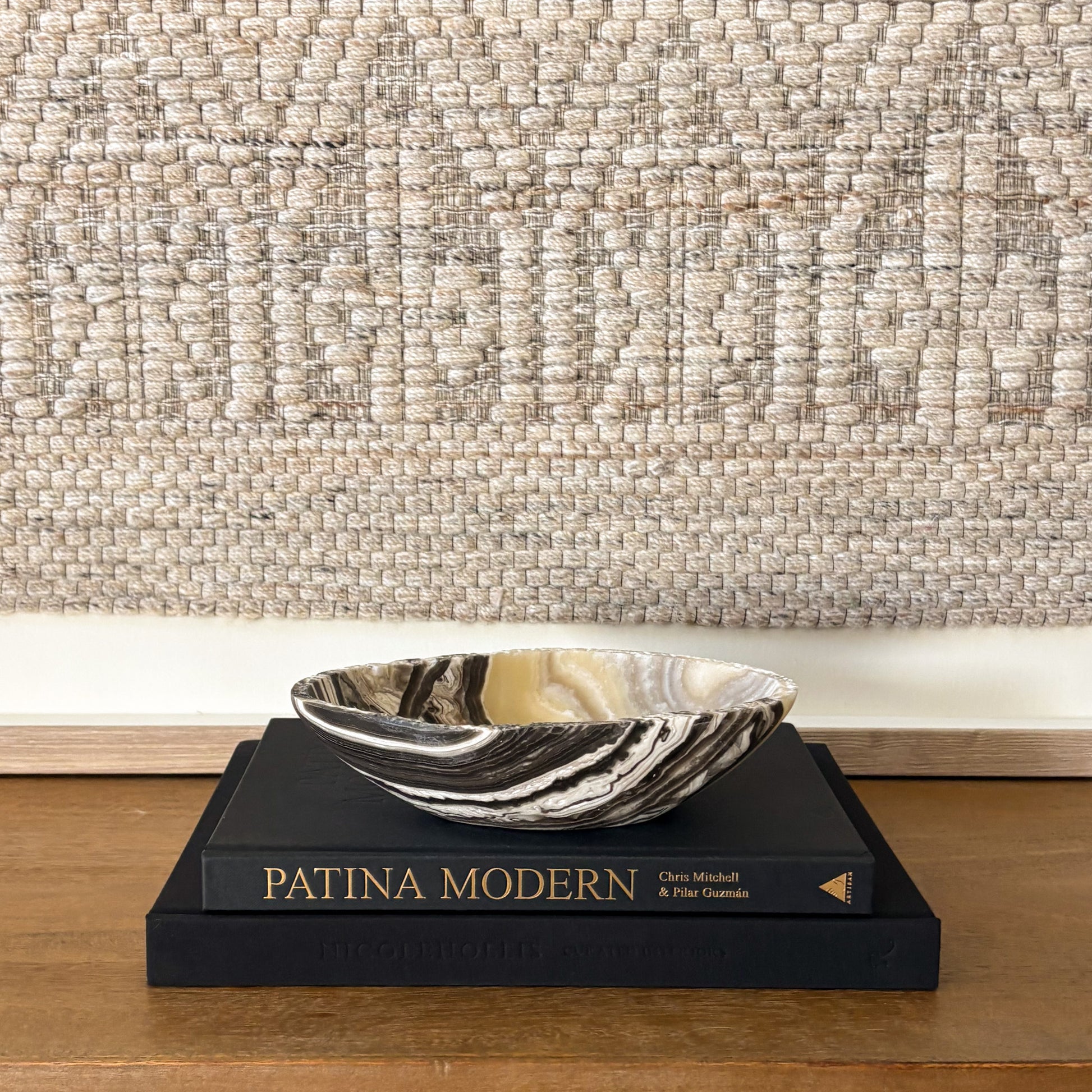 Small zebra onyx decorative bowl with natural striped stone pattern on wooden console