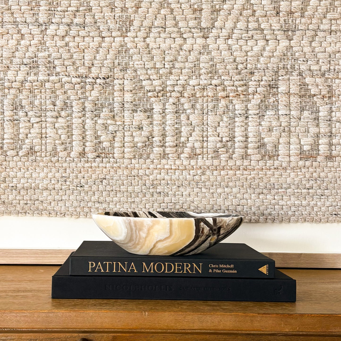 Small zebra onyx bowl styled on stacked design books in neutral modern interior