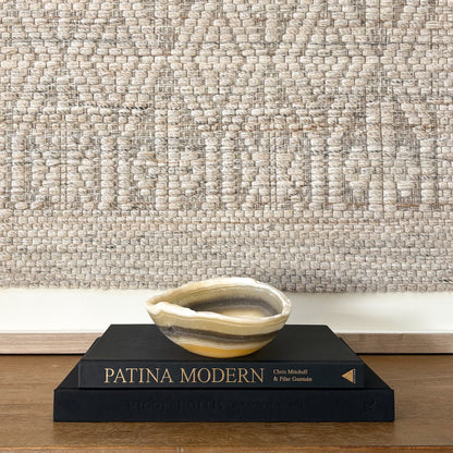 Artisan zebra onyx stone bowl displayed on stacked coffee table books