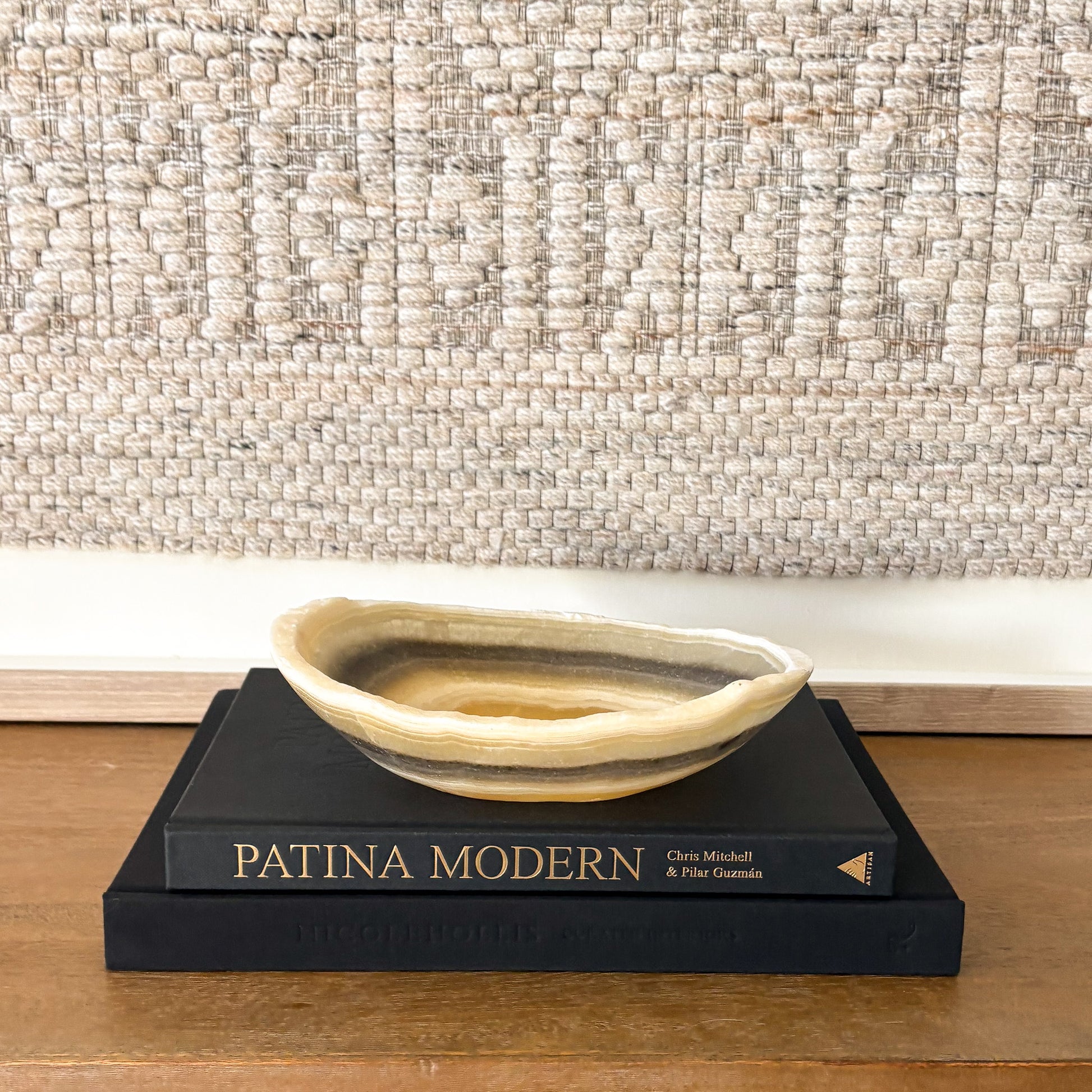 Small zebra onyx decorative bowl with natural striped stone pattern on wooden console