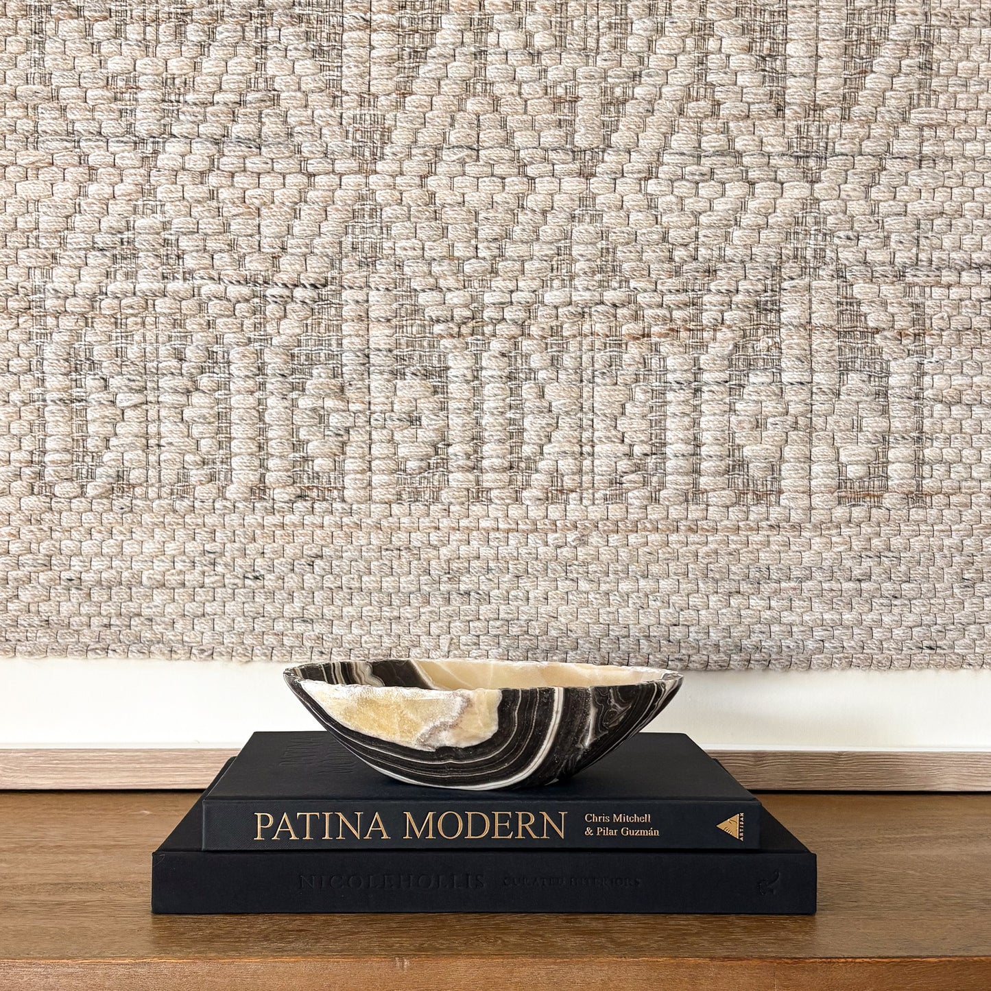 Small zebra onyx decorative bowl with natural striped stone pattern on wooden console