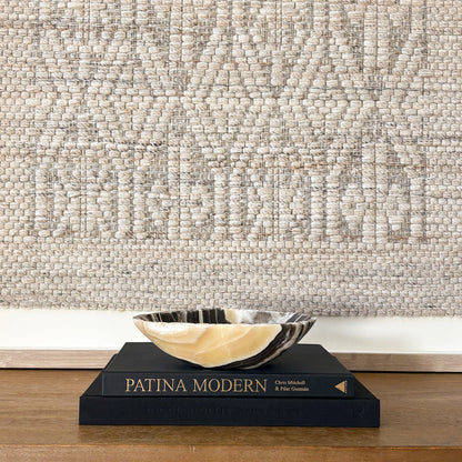Artisan zebra onyx stone bowl displayed on stacked coffee table books