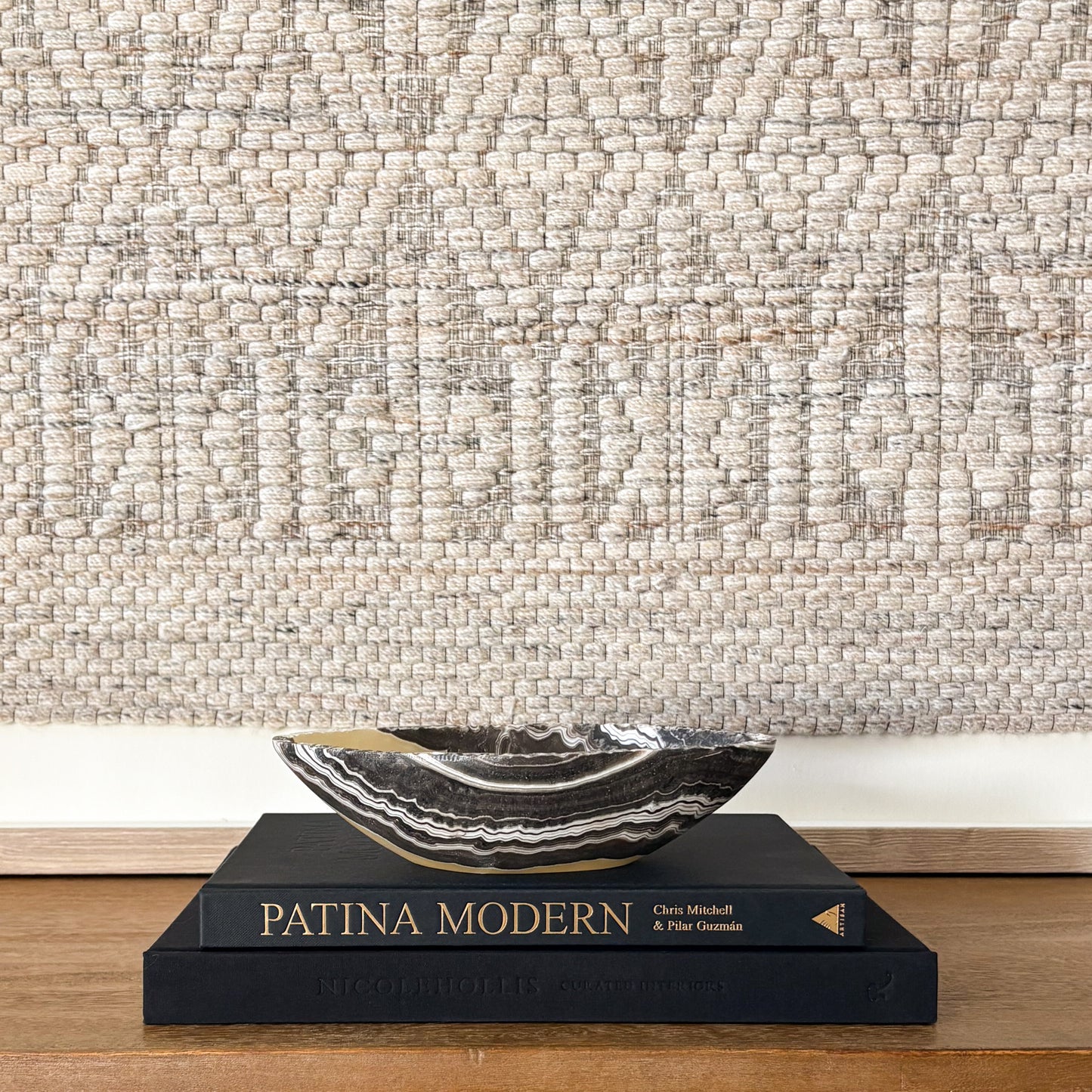 Hand carved zebra onyx bowl styled on Patina Modern book with neutral wall art backdrop