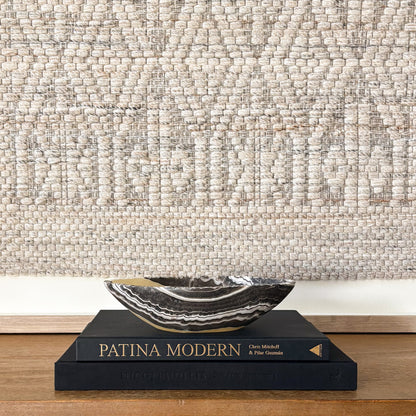 Hand carved zebra onyx bowl styled on Patina Modern book with neutral wall art backdrop