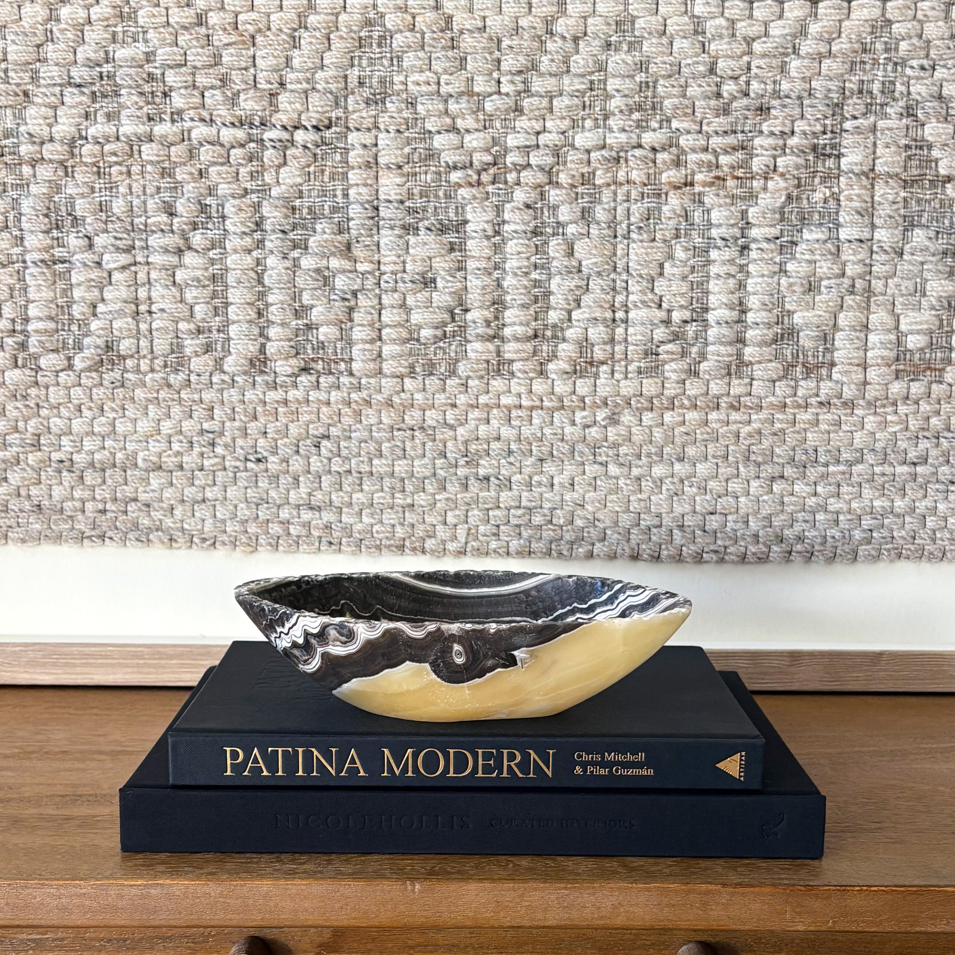 Small zebra onyx decorative bowl with natural striped stone pattern on wooden console