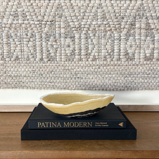 Small zebra onyx decorative bowl with natural striped stone pattern on wooden console