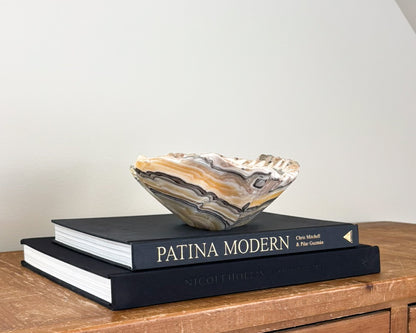Hand-carved natural stone bowl with intricate zebra onyx patterns in yellow, grey and black