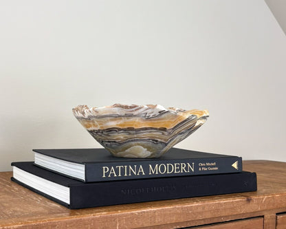 Unique zebra onyx bowl featuring sweeping ribbons of golden yellow, black, white and grey