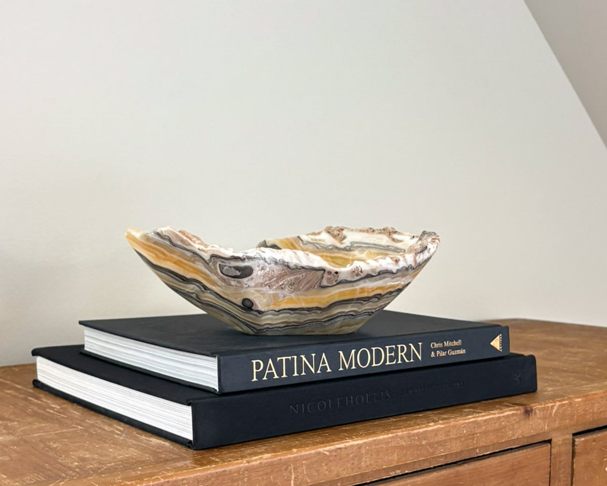 Sculptural zebra onyx bowl with striking multicolored bands and polished stone finish