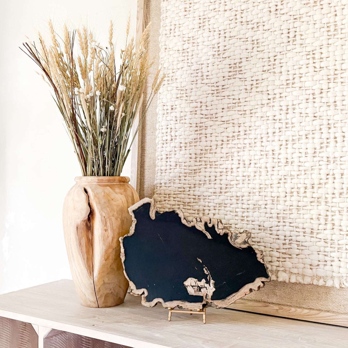 large black fossilized wood slab on bras easel stand