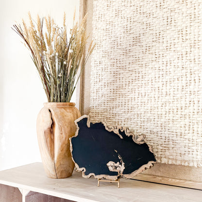 large black fossilized wood slab on bras easel stand