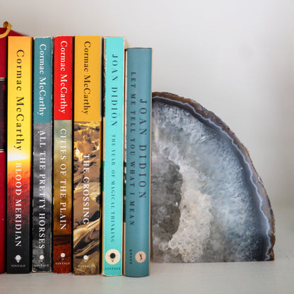 Polished blue Brazilian agate bookend pair with crystal druzy center decorating a modern bookshelf.