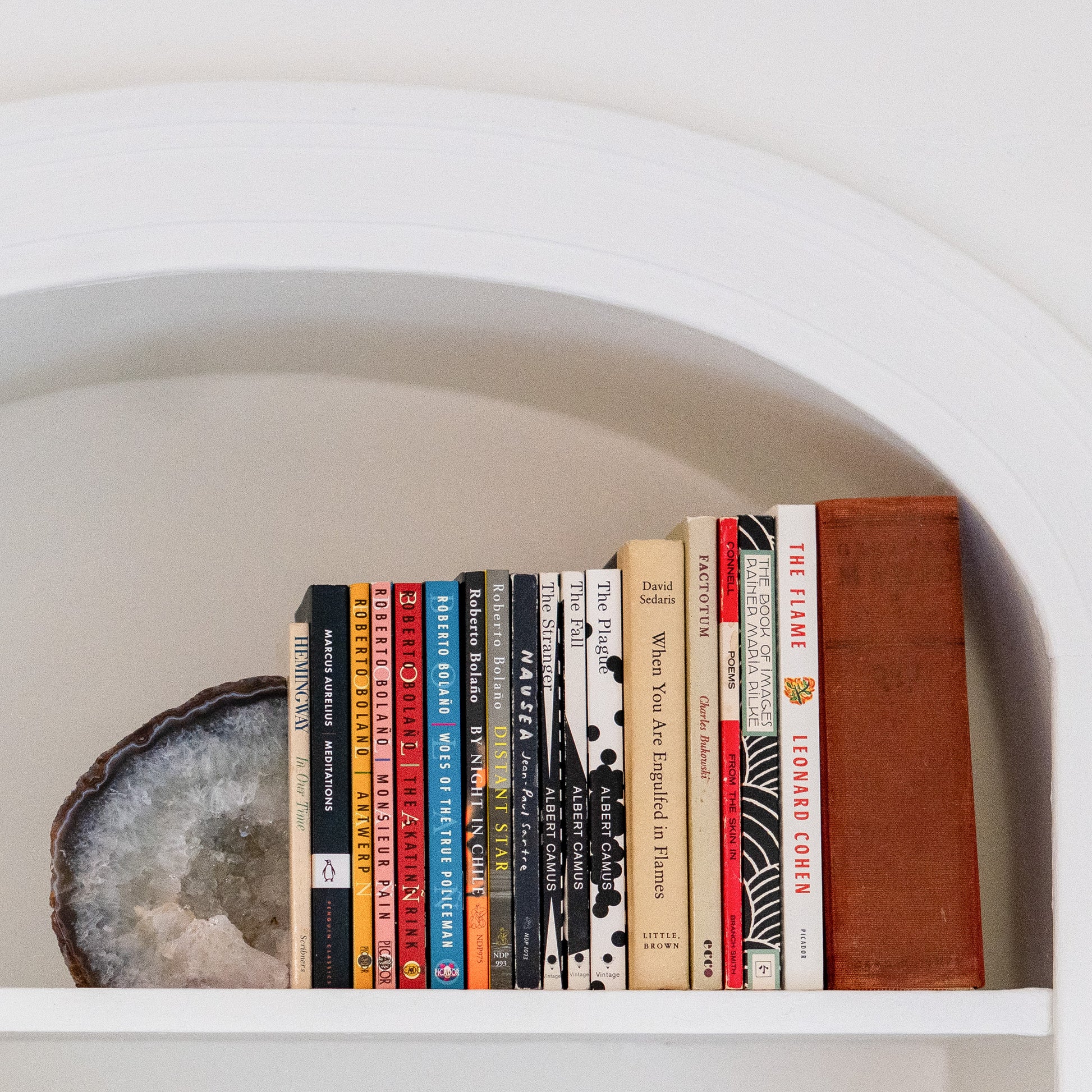 Natural blue agate druzy bookends with polished edges showcased on white built-in shelving.