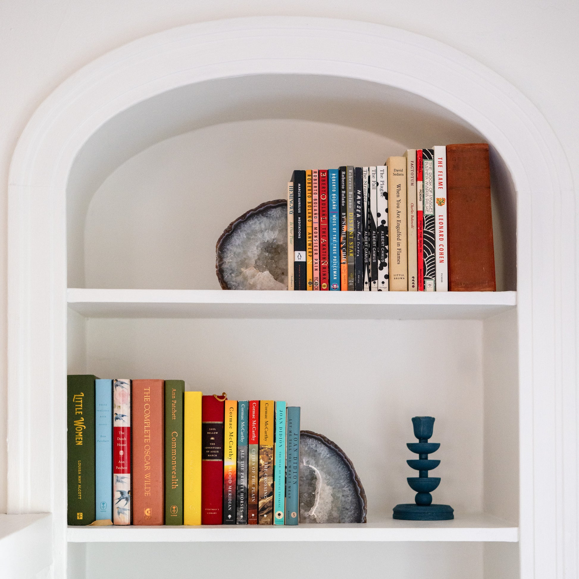 Large blue Brazilian agate bookend pair displayed on white built-in bookshelf with colorful books and modern decor.