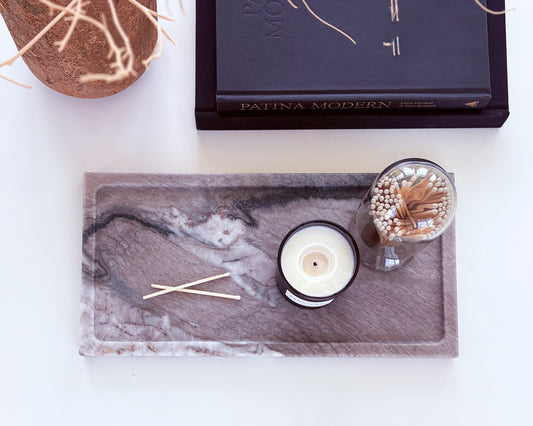 Large Pocahontas marble tray styled with a candle, glass match cloche, and luxury coffee table books on a modern white coffee table.
