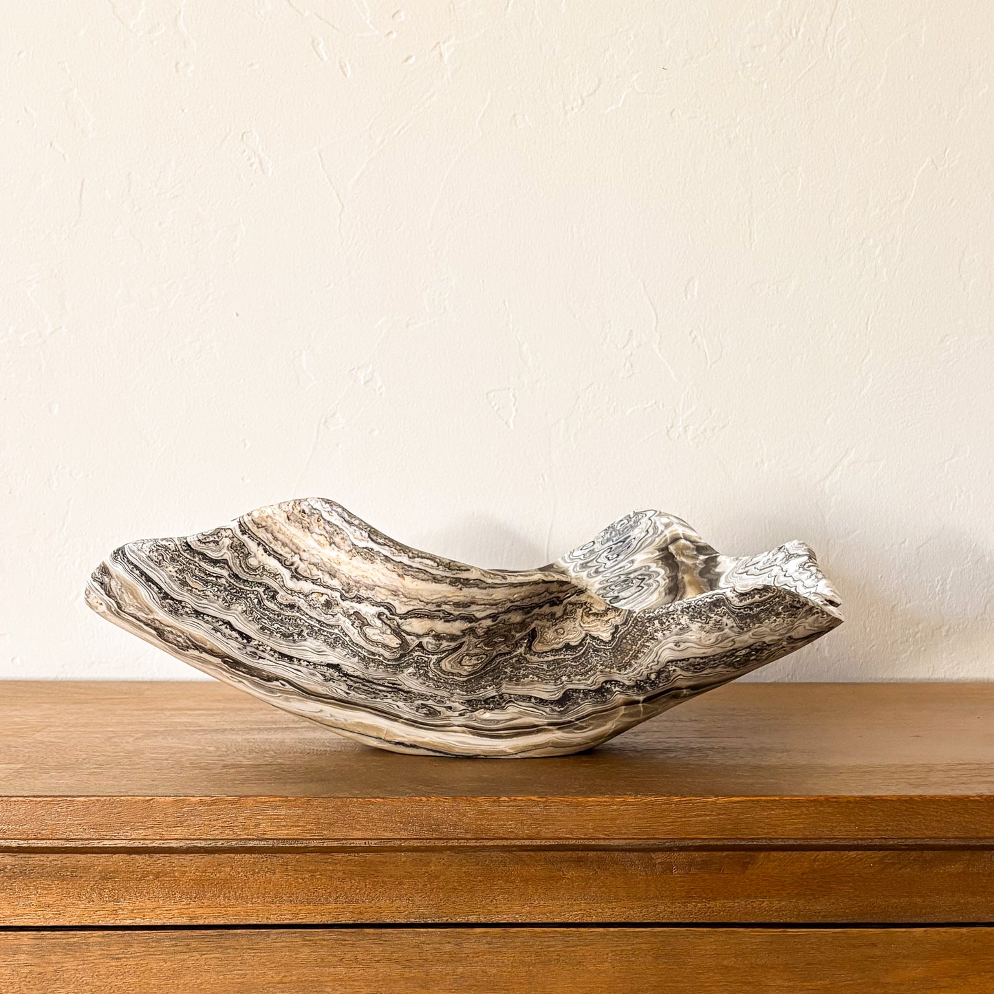 Large zebra onyx bowl hand carved from natural stone with striking black and ivory stripes, luxury decorative bowl.