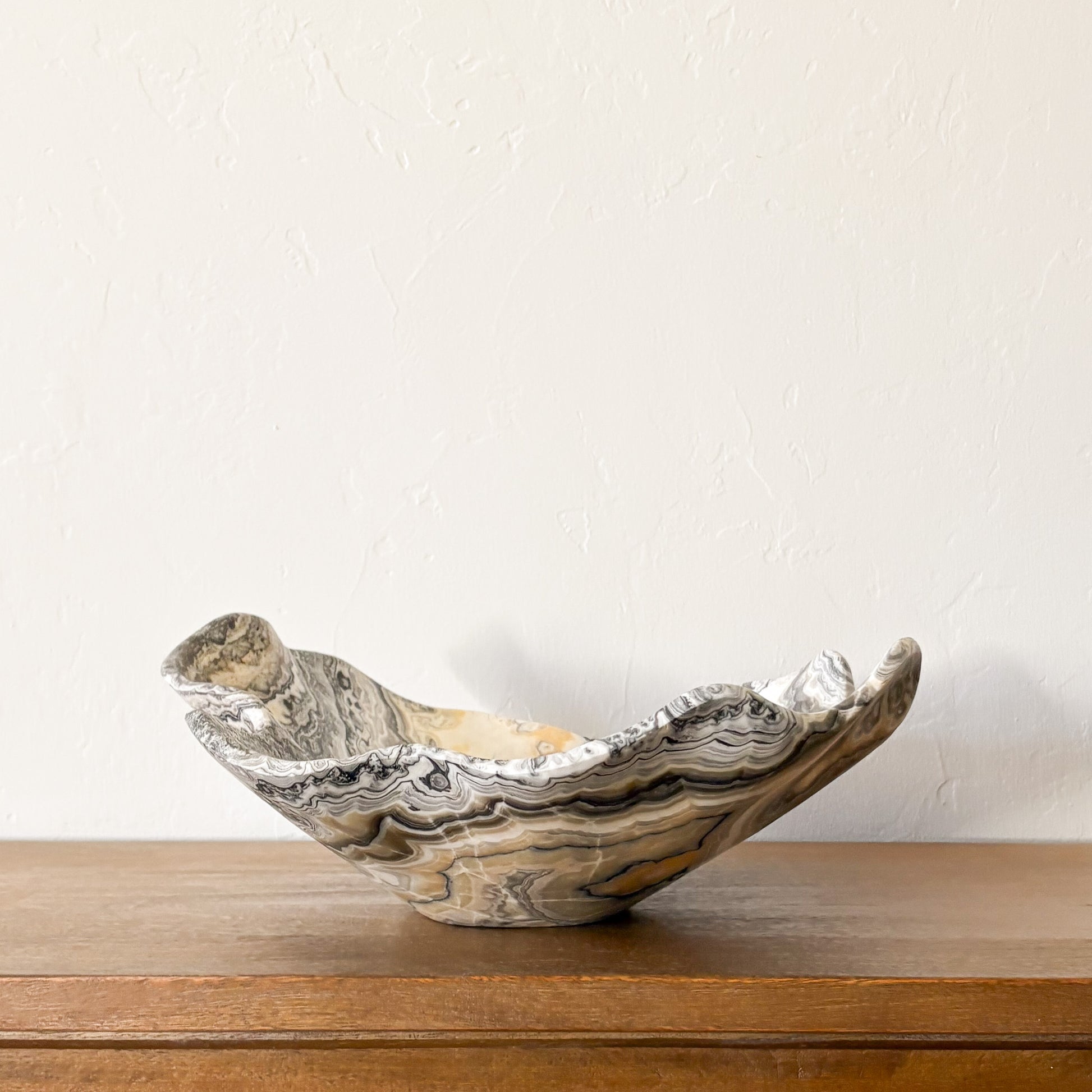 Large handcrafted zebra onyx bowl featuring natural black and cream banded stone, polished decorative centerpiece.