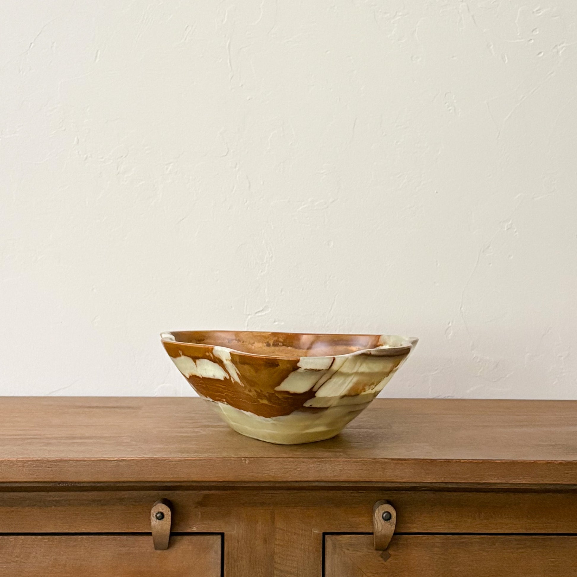 Luxury hand-carved onyx fruit bowl made from natural green stone with translucent layered banding.