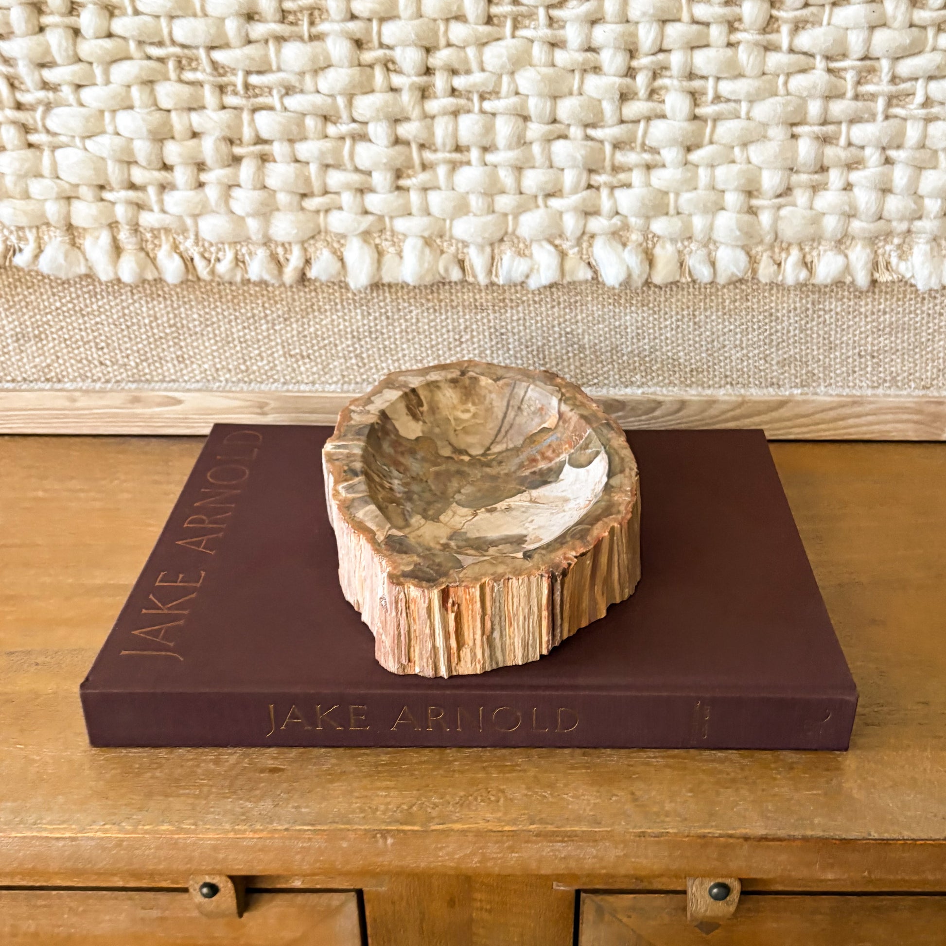 Stone petrified wood bowl styled with books and neutral interior design
