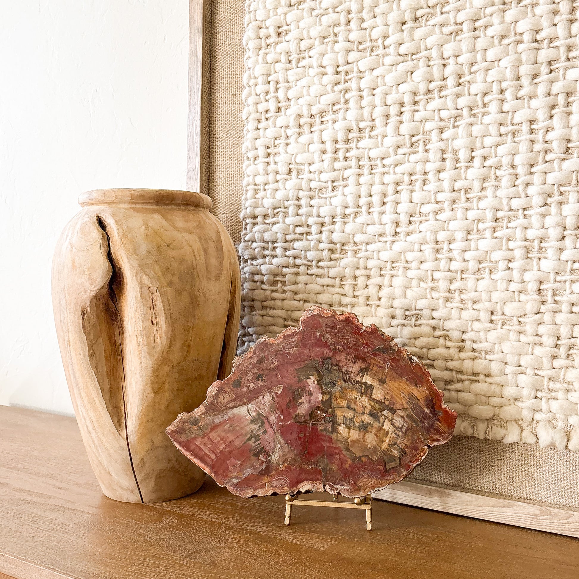 Decorative Madagascar petrified wood slab in rich red and golden hues on metal stand