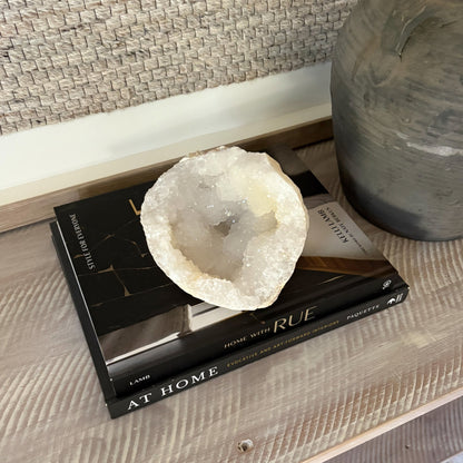 Decorative quartz geode on a book with a vase in the background