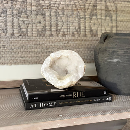 Decorative geode on books with a textured wall in the background