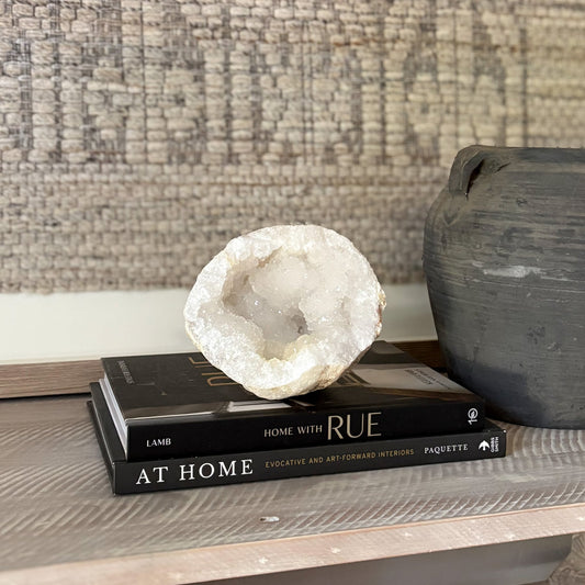 Decorative geode on books with a textured wall in the background