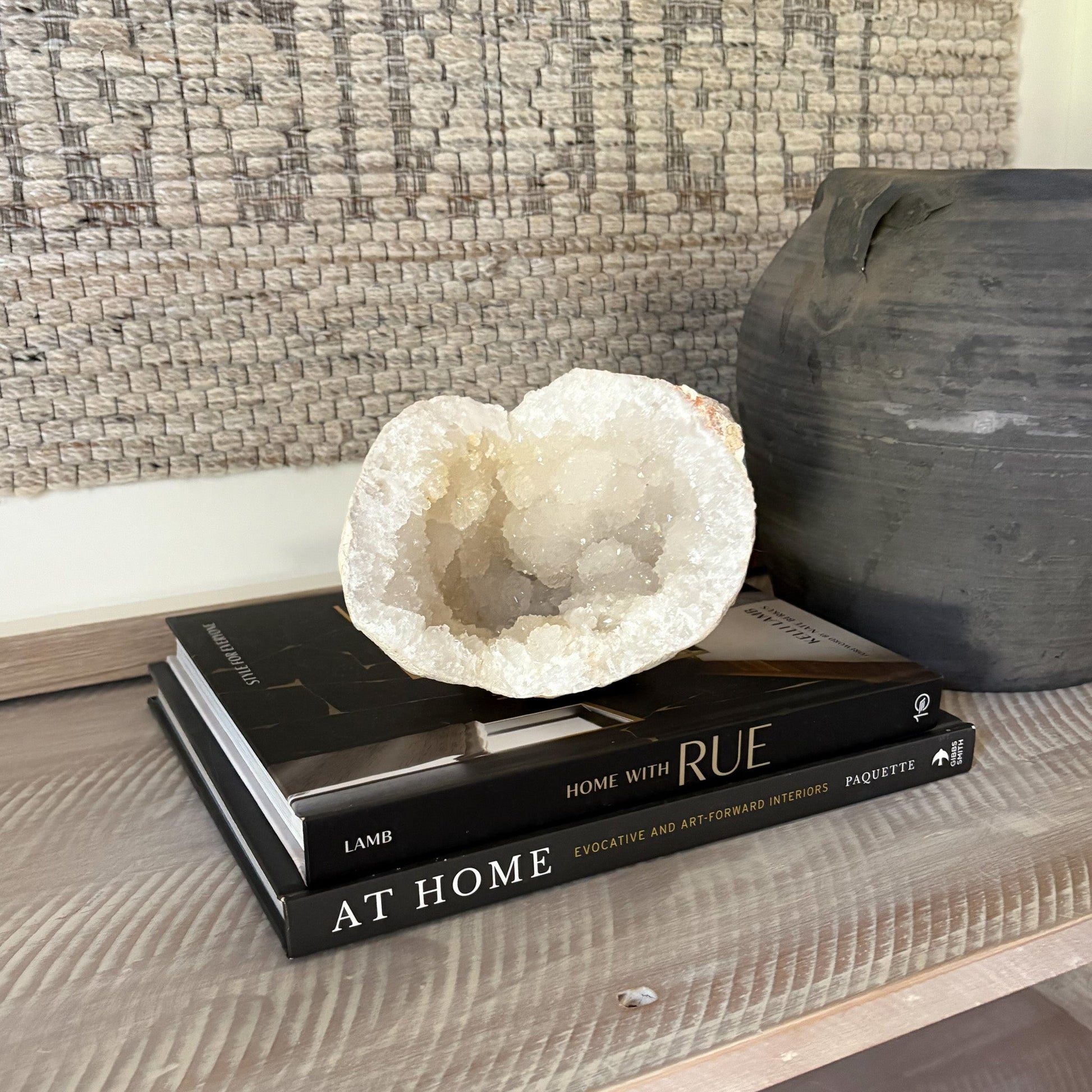 Decorative quartz geode on top of books with a textured wall in the background