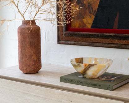 Olive green onyx catchall bowl displayed on a coffee table