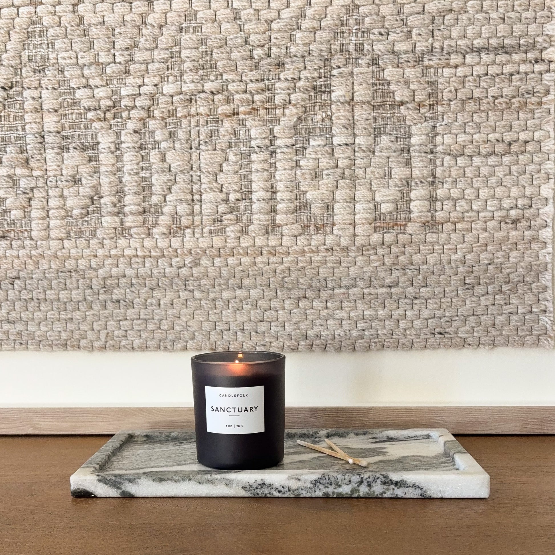 Rectangular black and white marble tray styled with candle