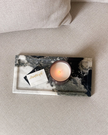 Black and white Panda marble tray styled on a neutral upholstered ottoman