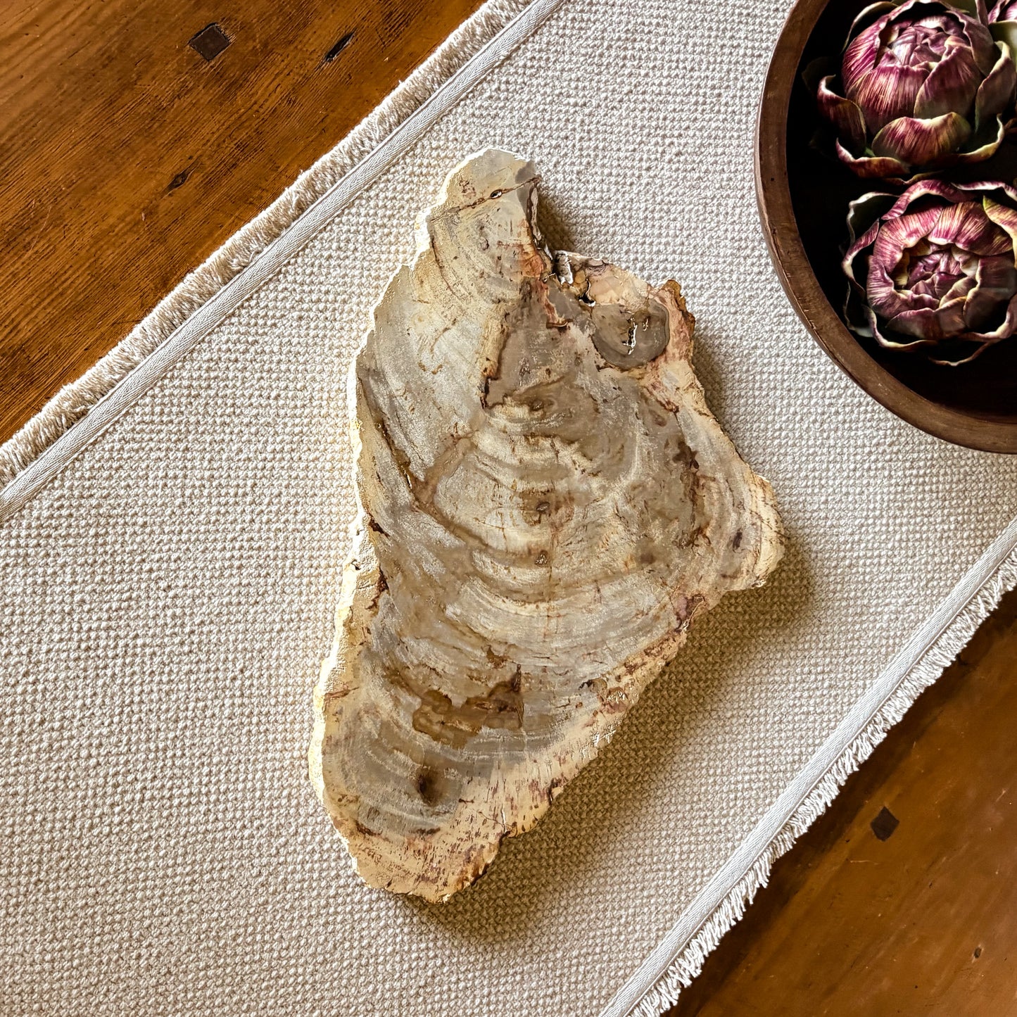 Unique serving board made from Indonesian petrified wood displaying intricate mineralized wood patterns