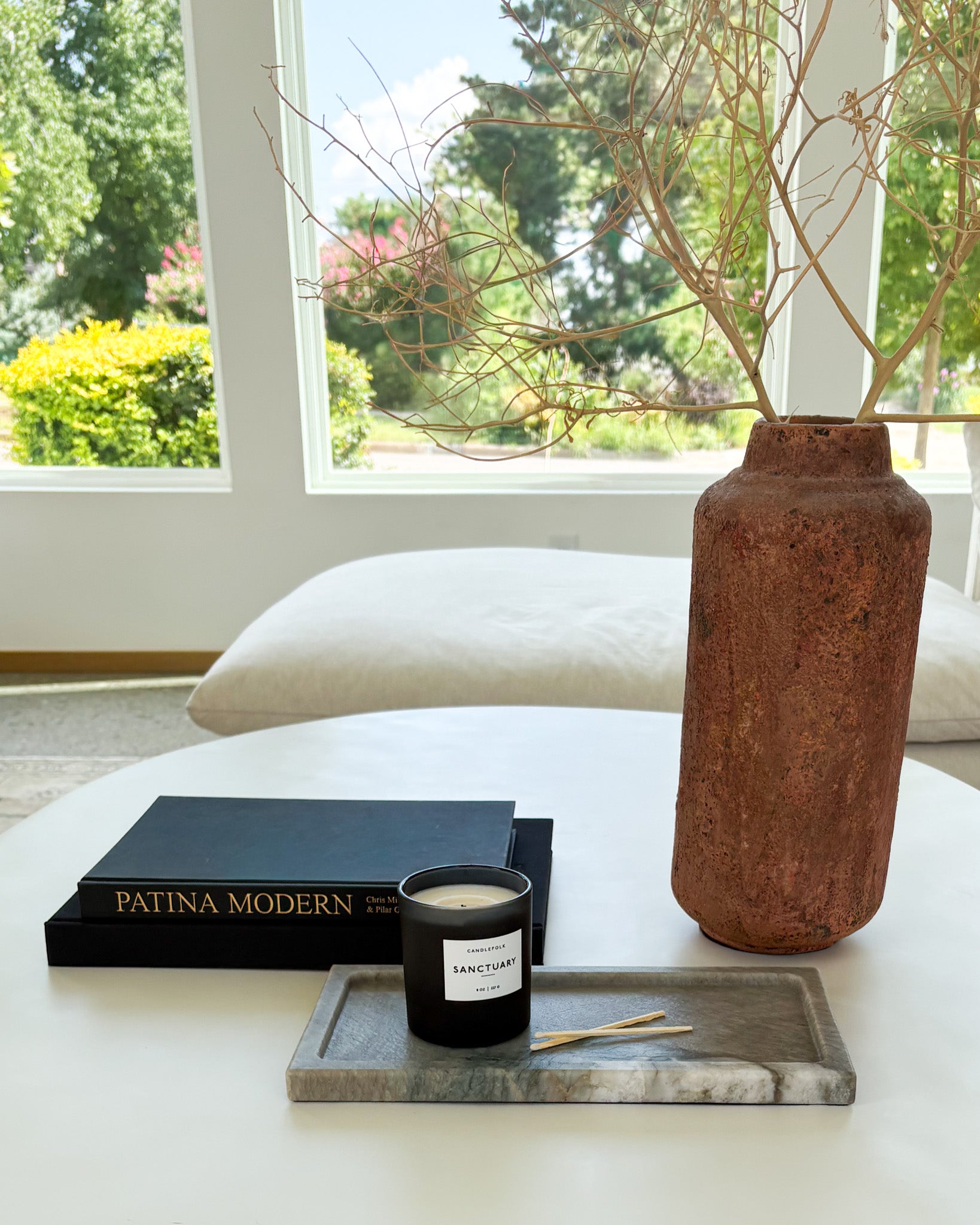 Decorative gray Pocahontas marble tray with candle on a modern coffee table in a luxury living room