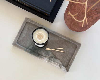 Decorative gray Pocahontas marble tray on a coffee table with candle in a modern organic living room