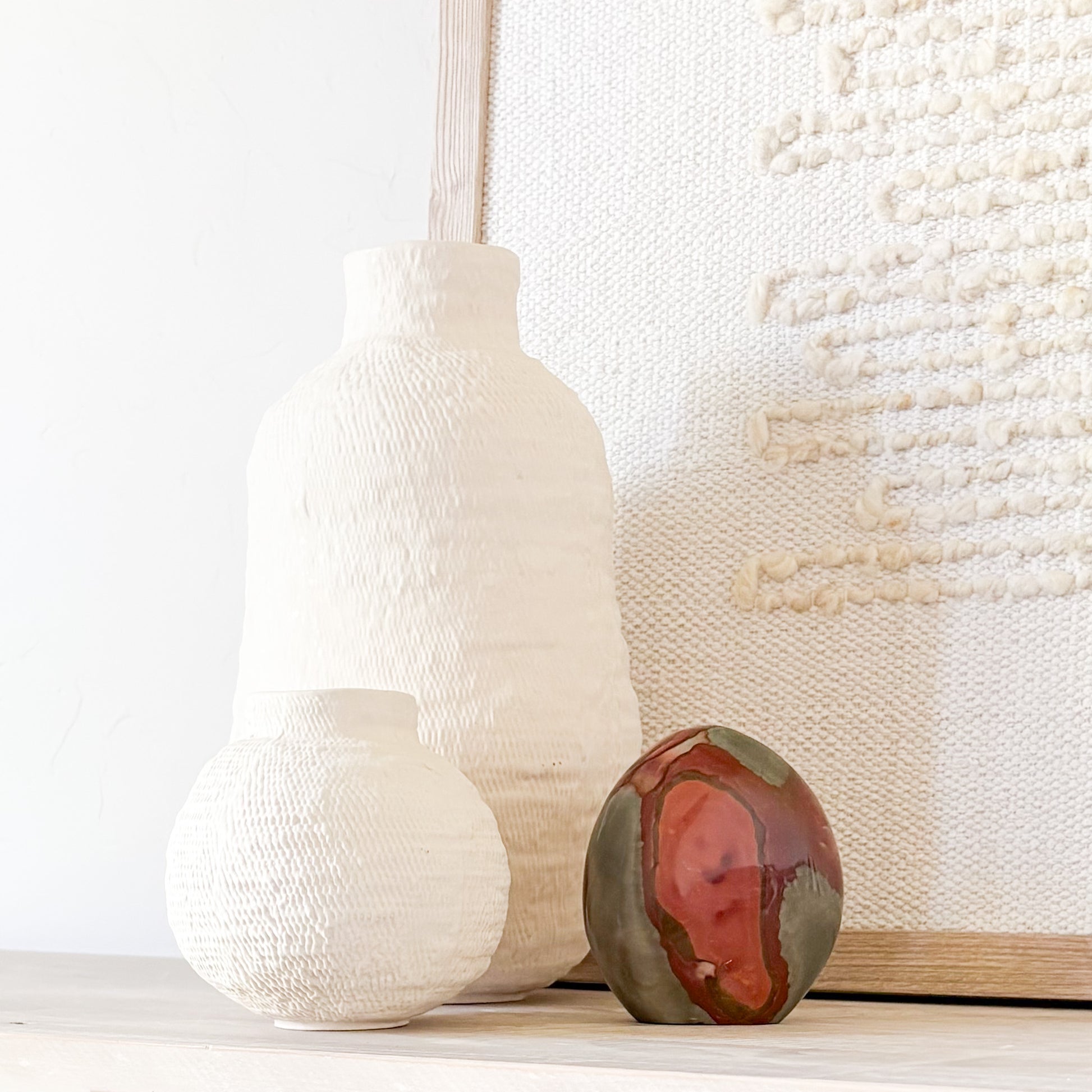 Polychrome jasper sculpture styled on modern shelf with minimalist home decor