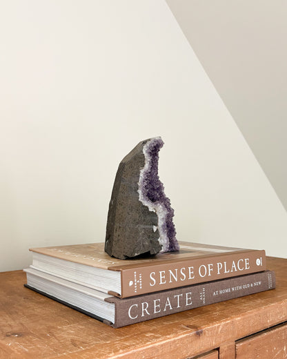 Upright rainbow amethyst geode with flat base for display