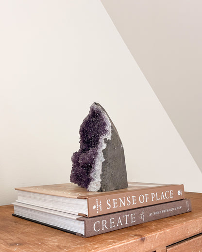Rainbow amethyst geode with natural stone matrix and crystal face