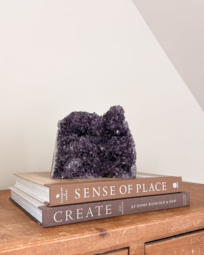 Natural rainbow amethyst geode with violet and lavender crystals