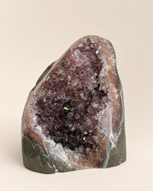 Natural amethyst geode with sparkling mauve-purple crystals and rough stone exterior