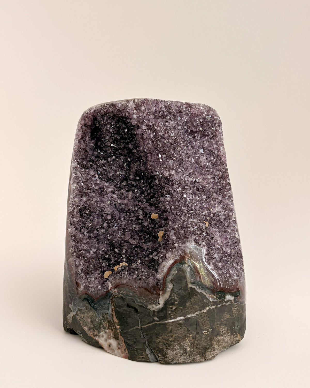 Natural amethyst geode with sparkling mauve-purple crystals and rough stone exterior