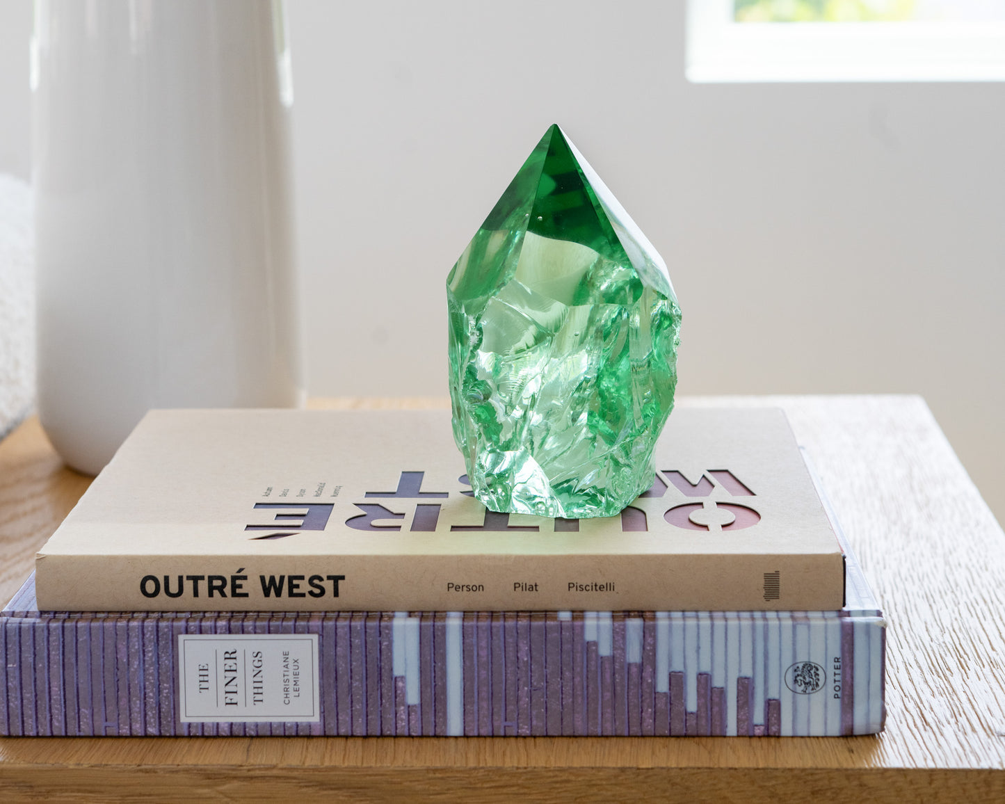 Rustic green glass point displayed on a wood side table in a bright neutral living room