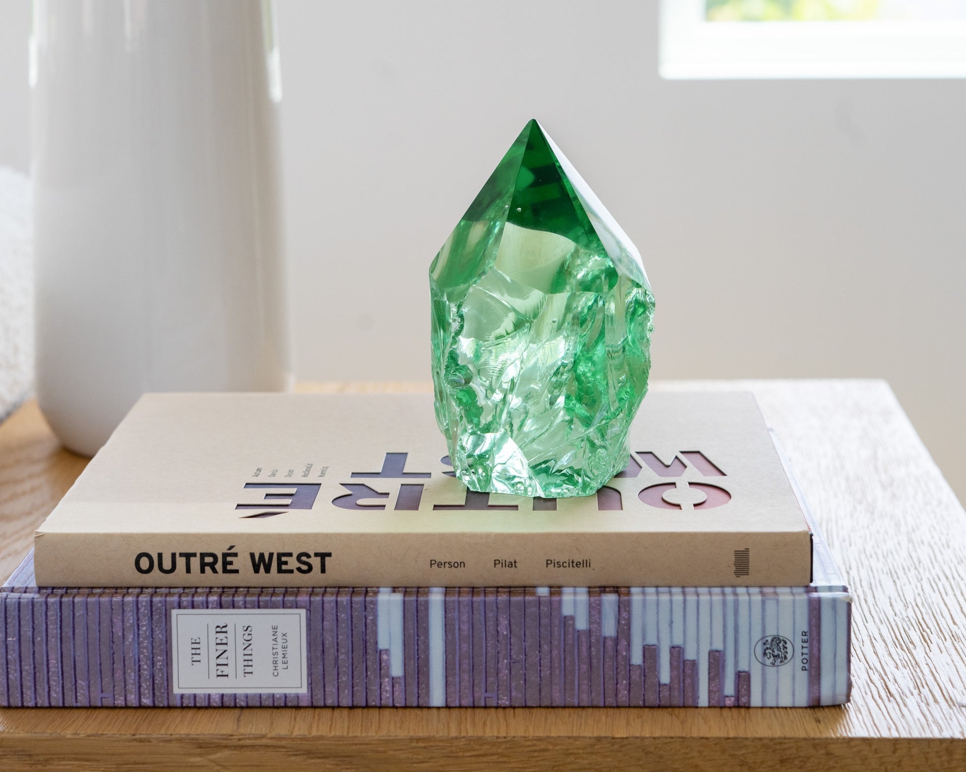 Rustic green glass point displayed on a wood side table in a bright neutral living room