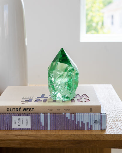 Handcrafted rustic green glass point displayed on a coffee table with books